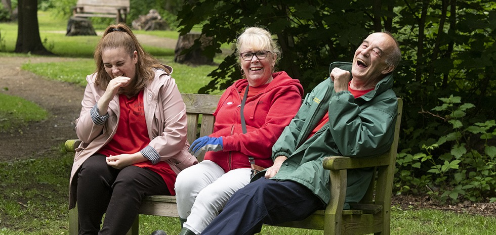 Laughing people on a park bench