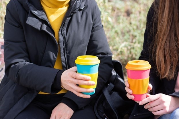person holding a reusable coffee cup